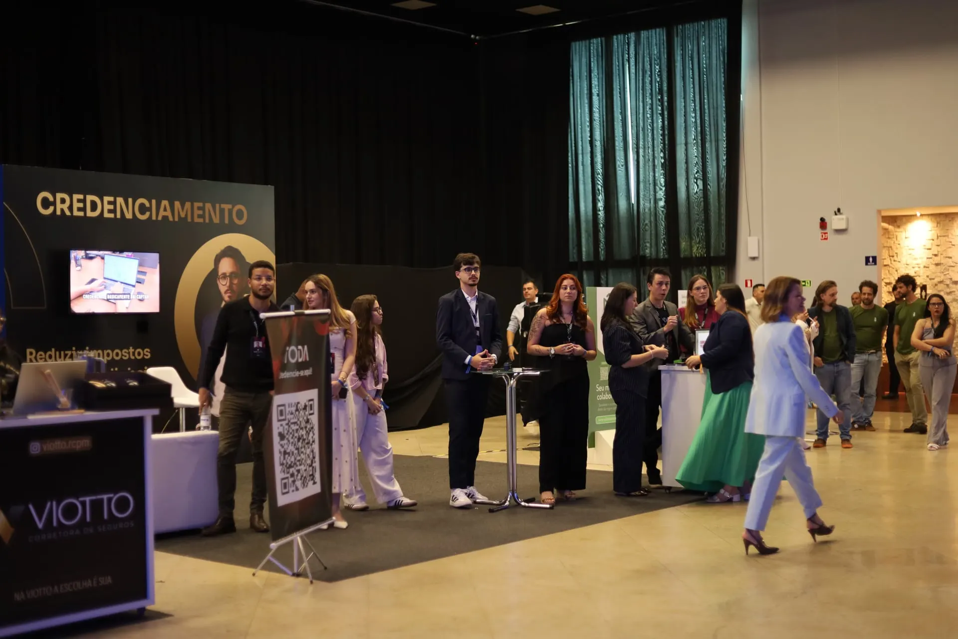 Profissionais circulam e conversam em um espaço de evento