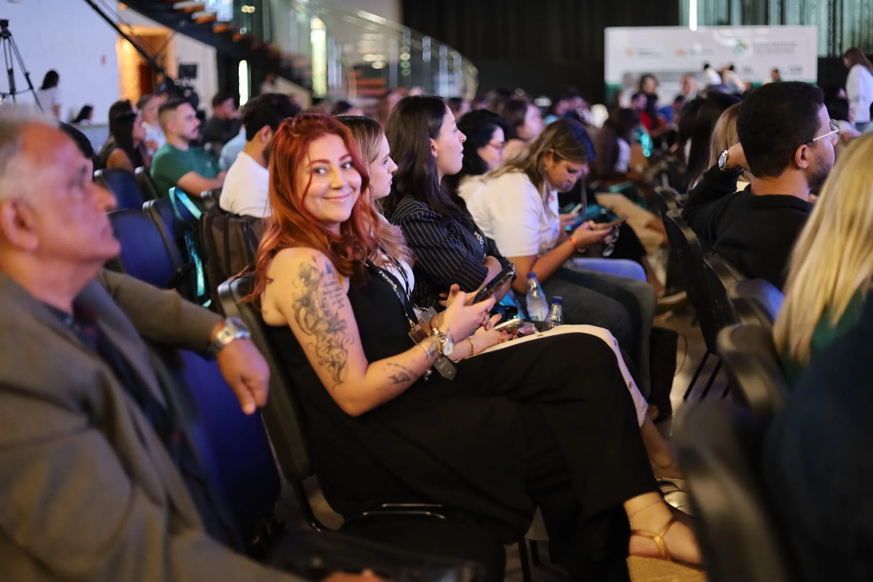 Participantes acompanham a programação em um auditório