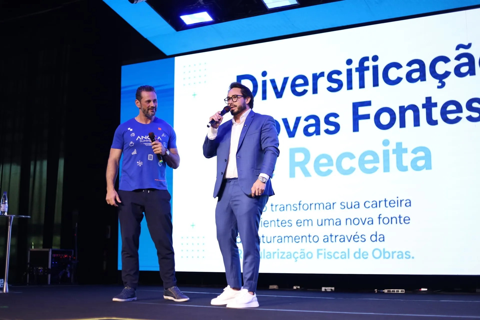 Kleber Toda conversa ao microfone com outro apresentador no palco