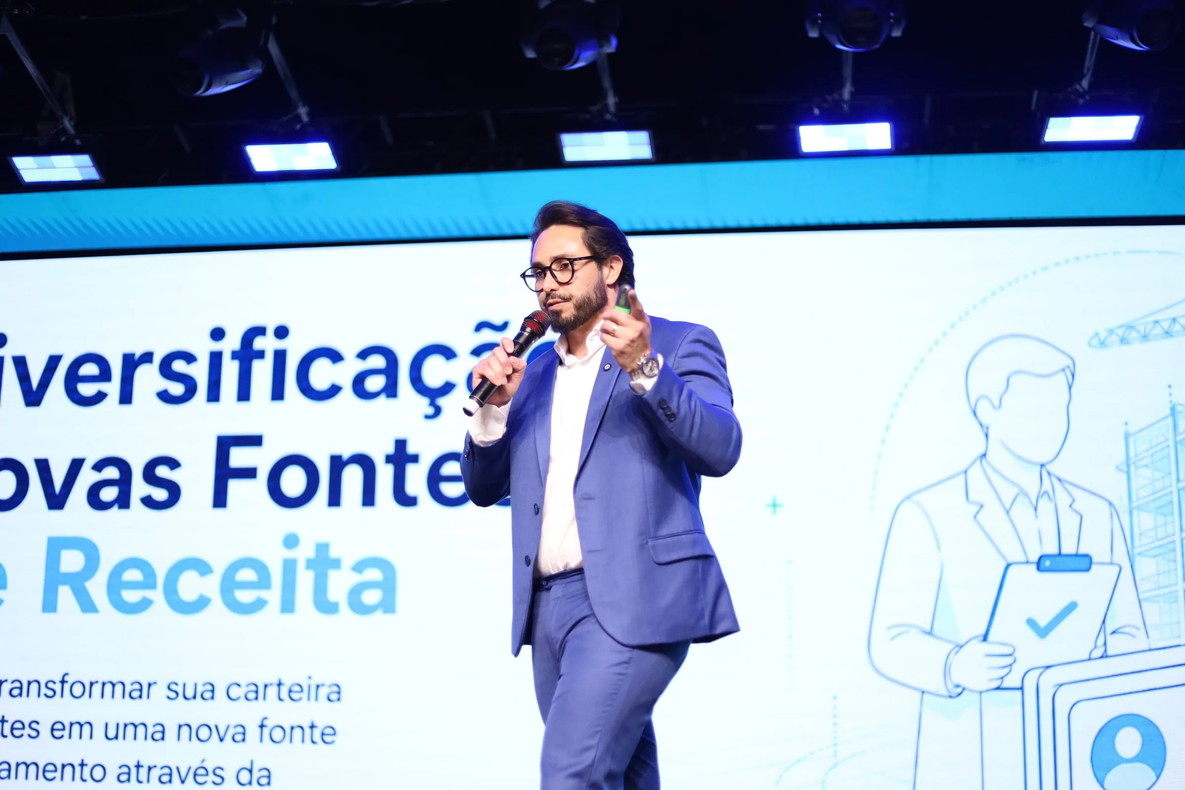 Kleber Toda fala ao microfone diante de uma apresentação sobre regularização de obras