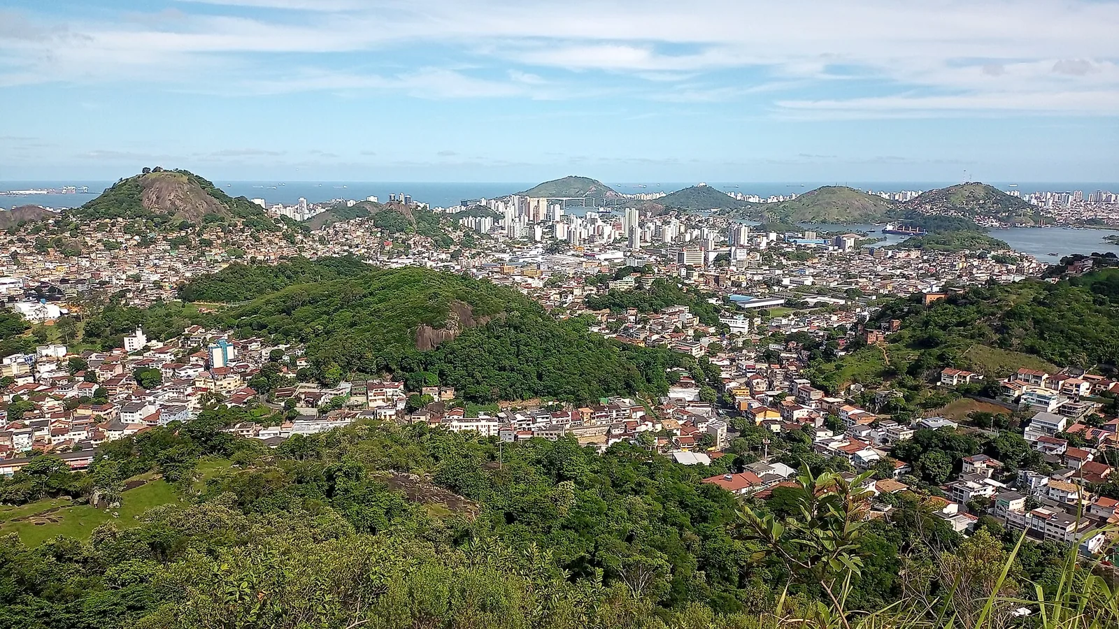 Vista panorâmica de Vitória entre morros, bairros e litoral